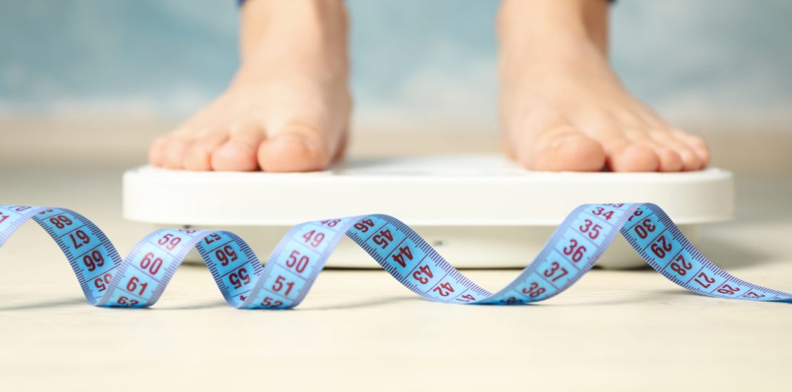 Woman stands on the scales. Measuring tape. Weight loss